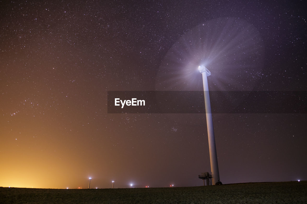 Low angle view of windmill against star field at night