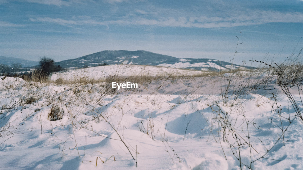 Snow covered landscape against sky