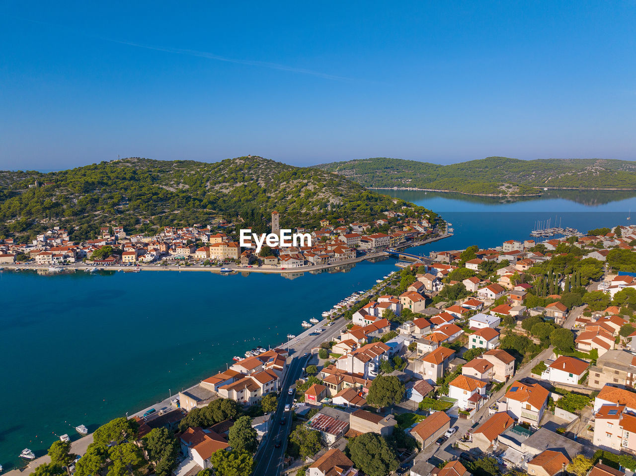 high angle view of townscape by sea against clear sky