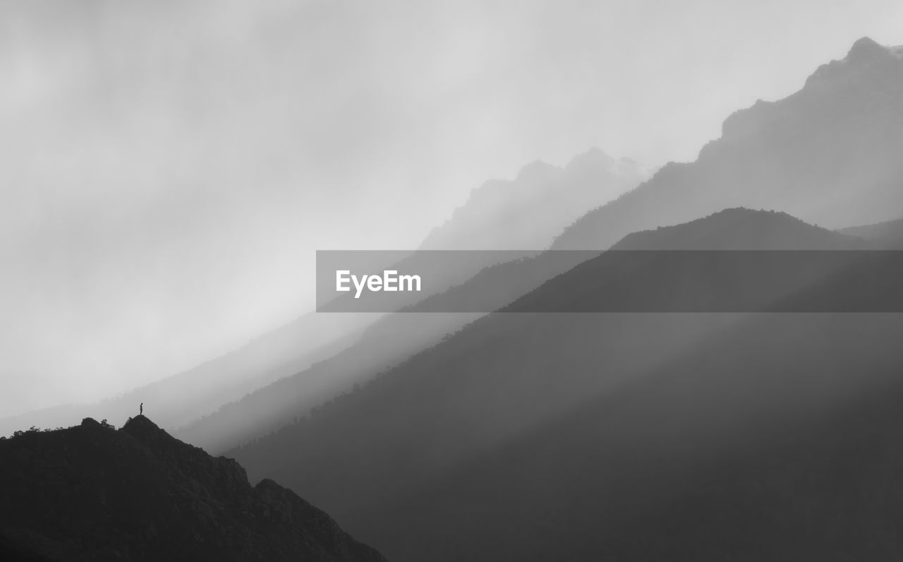 Scenic view of silhouette mountains during foggy weather