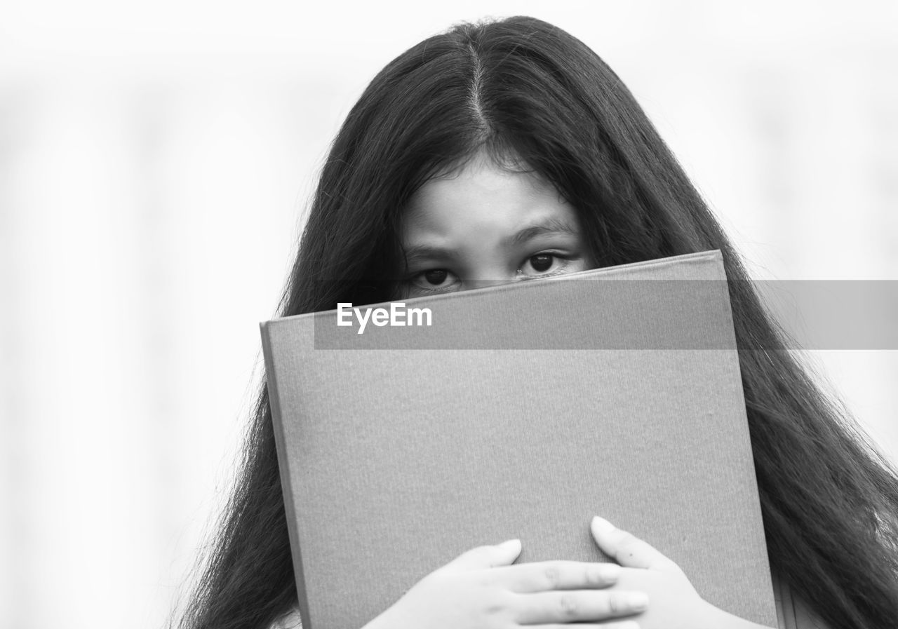 PORTRAIT OF WOMAN HOLDING BOOK WITH HAND ON OPEN