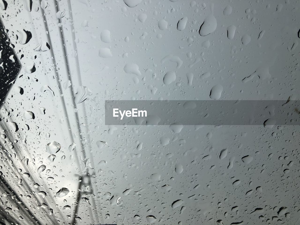 CLOSE-UP OF RAINDROPS ON GLASS WINDOW