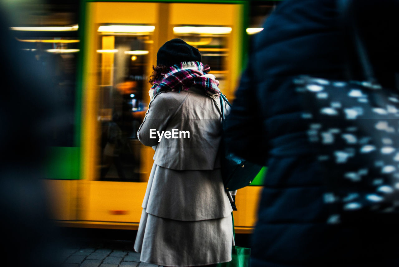 Rear view of woman standing by cable car on street