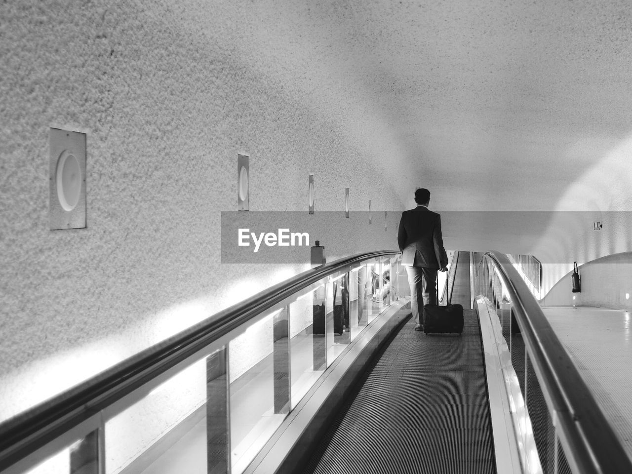 Rear view of businessman on escalator