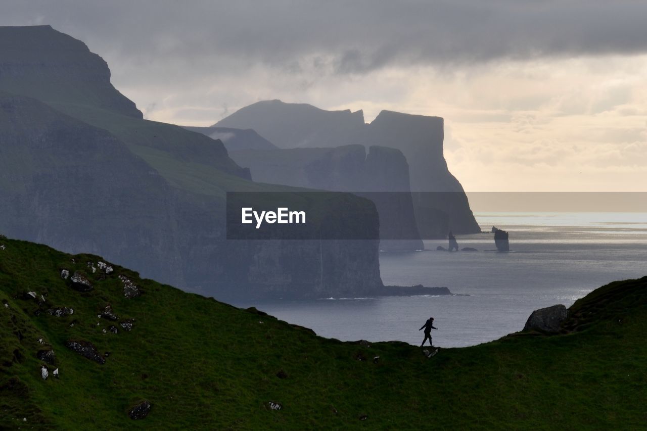 Scenic view of sea and mountains against sky