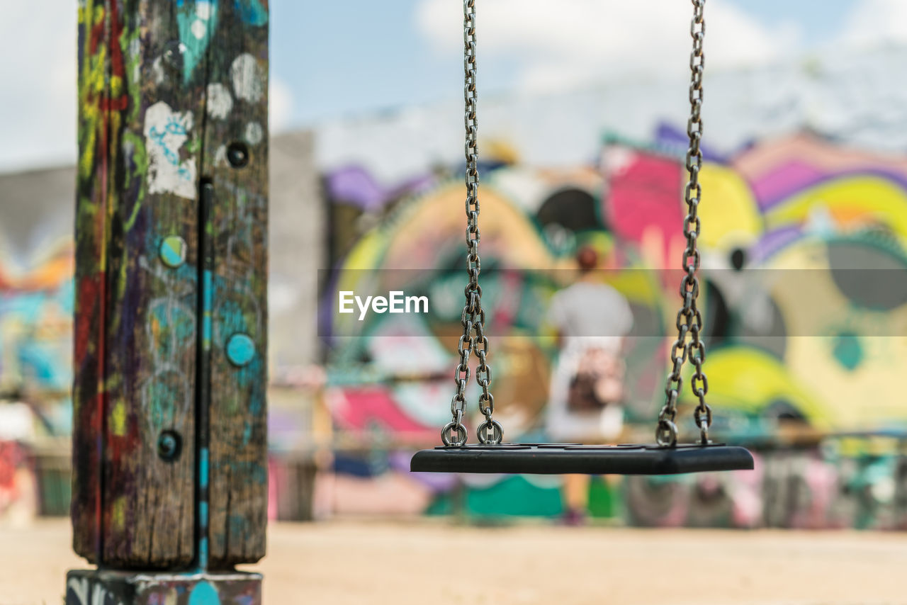 CLOSE-UP OF SWING HANGING ON METAL