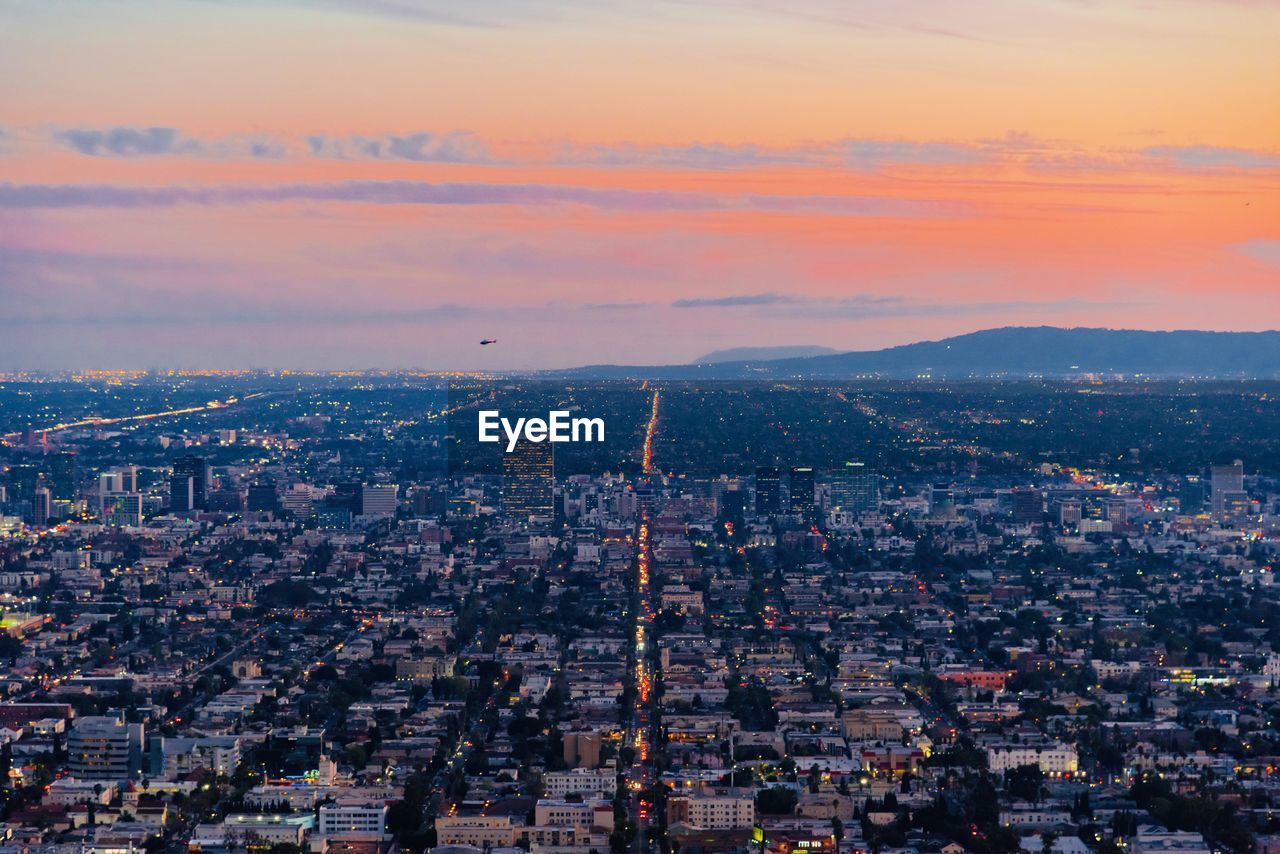 High angle view of illuminated buildings against sky during sunset