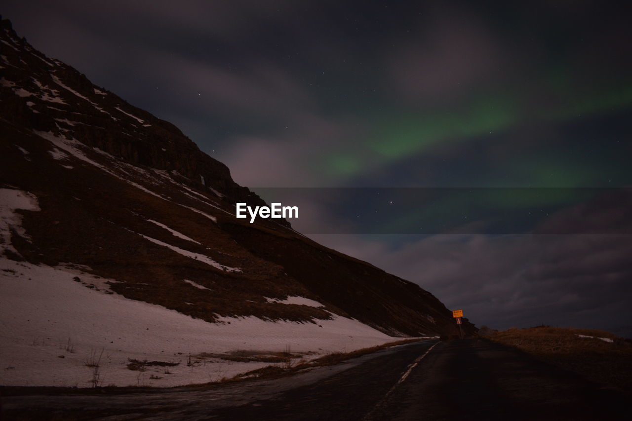 Scenic view of snowcapped mountain against sky with northern lights 