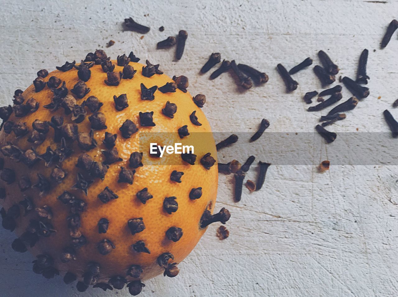 Directly above shot of orange studded with cloves on table