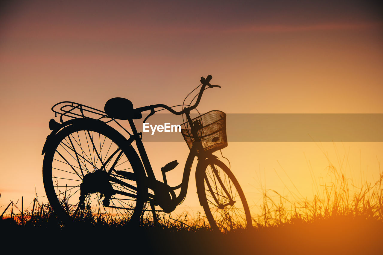 SILHOUETTE BICYCLE ON FIELD DURING SUNSET