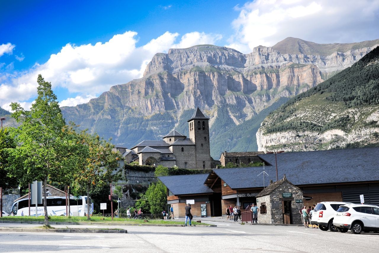 BUILT STRUCTURES AGAINST MOUNTAIN RANGE AND SKY