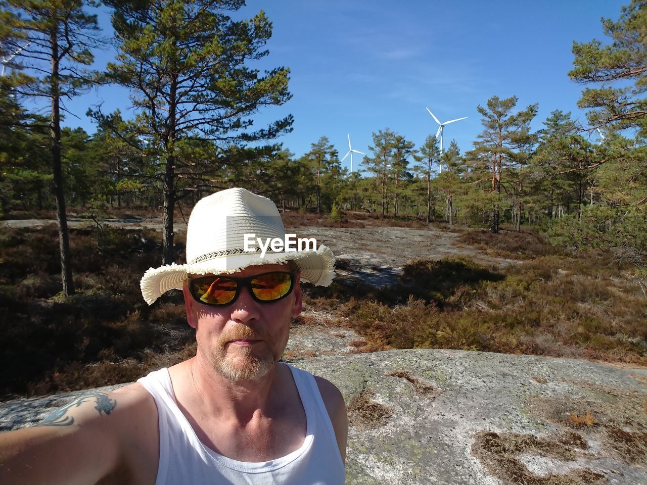 Portrait of man wearing sunglasses against trees