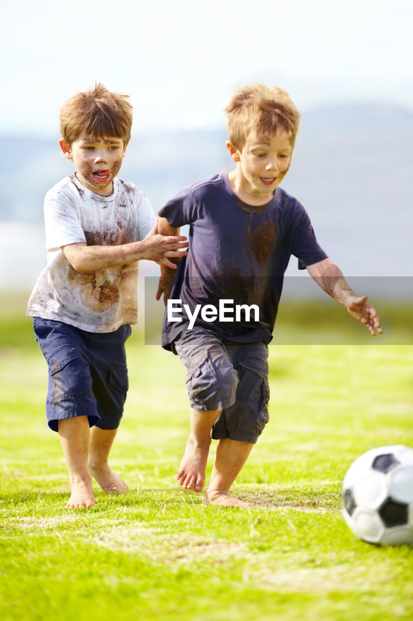 full length of man playing soccer on field