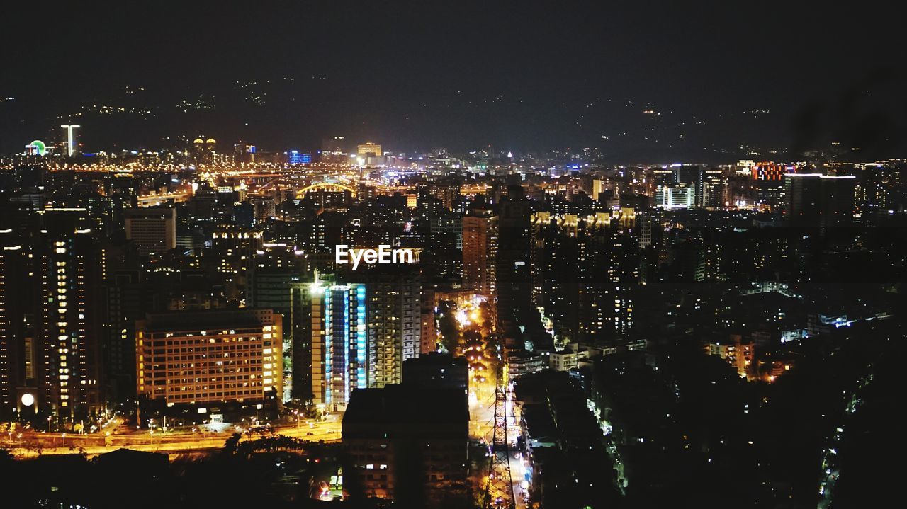 ILLUMINATED CITY AGAINST SKY AT NIGHT