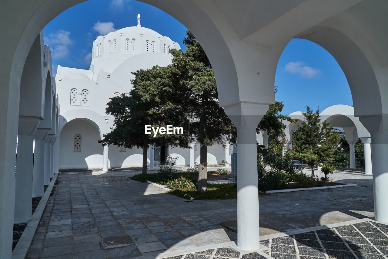 architecture, arch, built structure, building exterior, building, nature, estate, tree, sky, plant, travel destinations, religion, no people, place of worship, day, outdoors, belief, city, courtyard, architectural column, travel, blue, palm tree, landmark