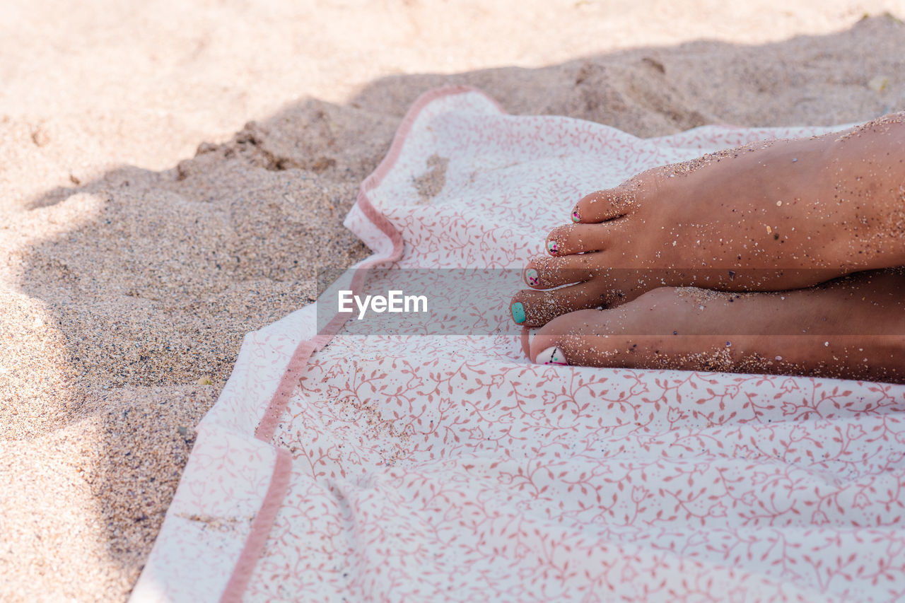 Low section of woman relaxing at beach