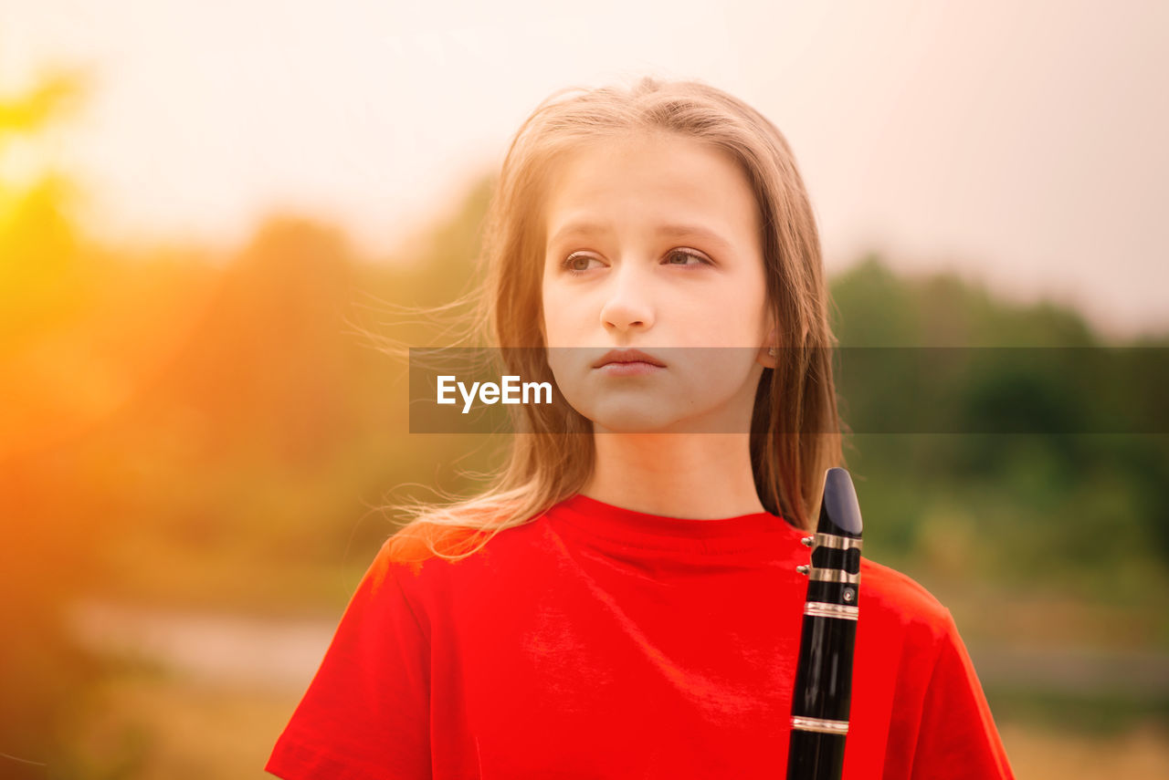 portrait of young woman standing against sky