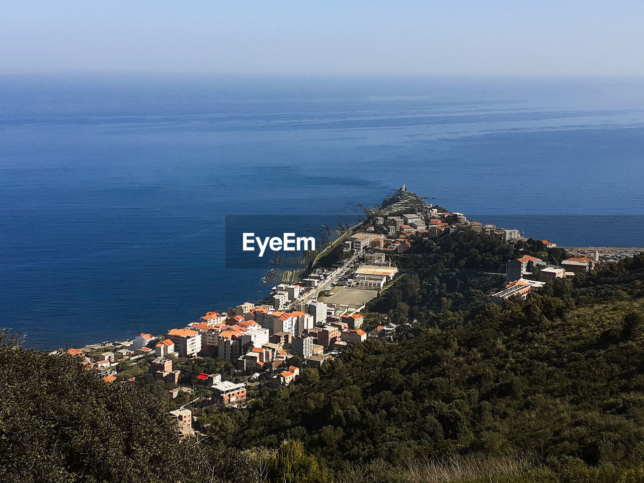 HIGH ANGLE VIEW OF BUILDINGS AGAINST SEA