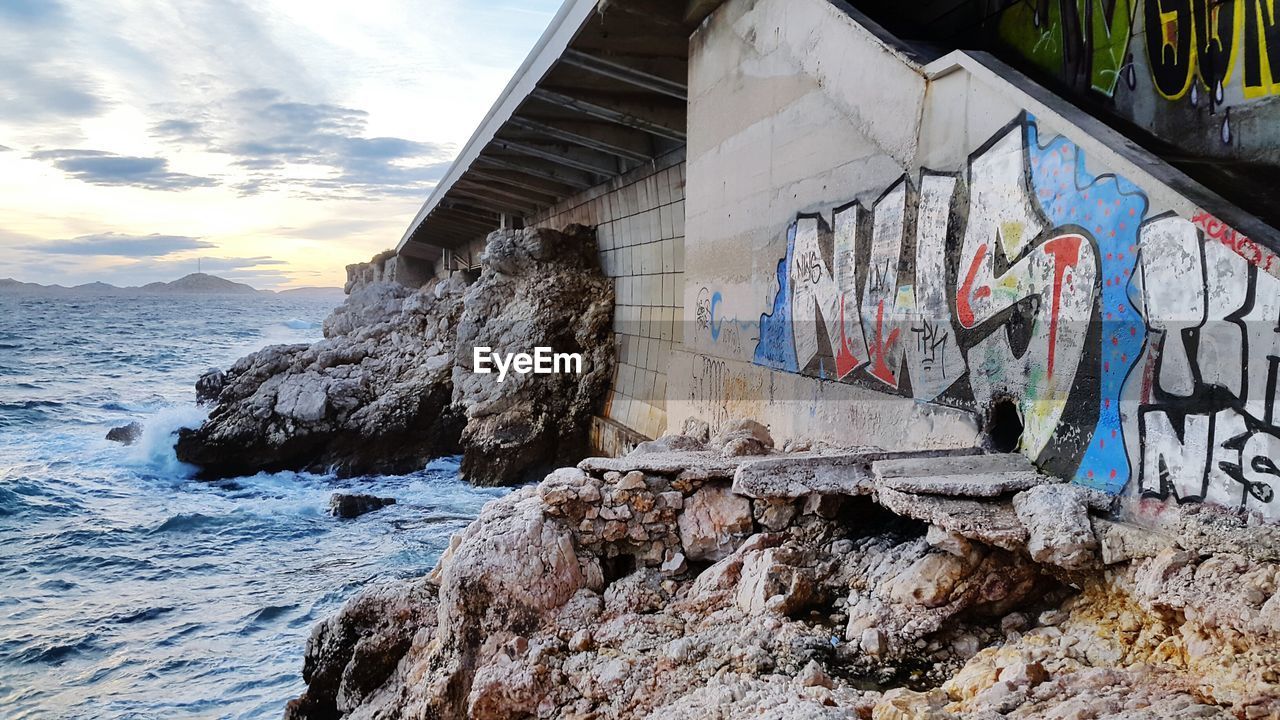 Graffiti on wall of building by sea