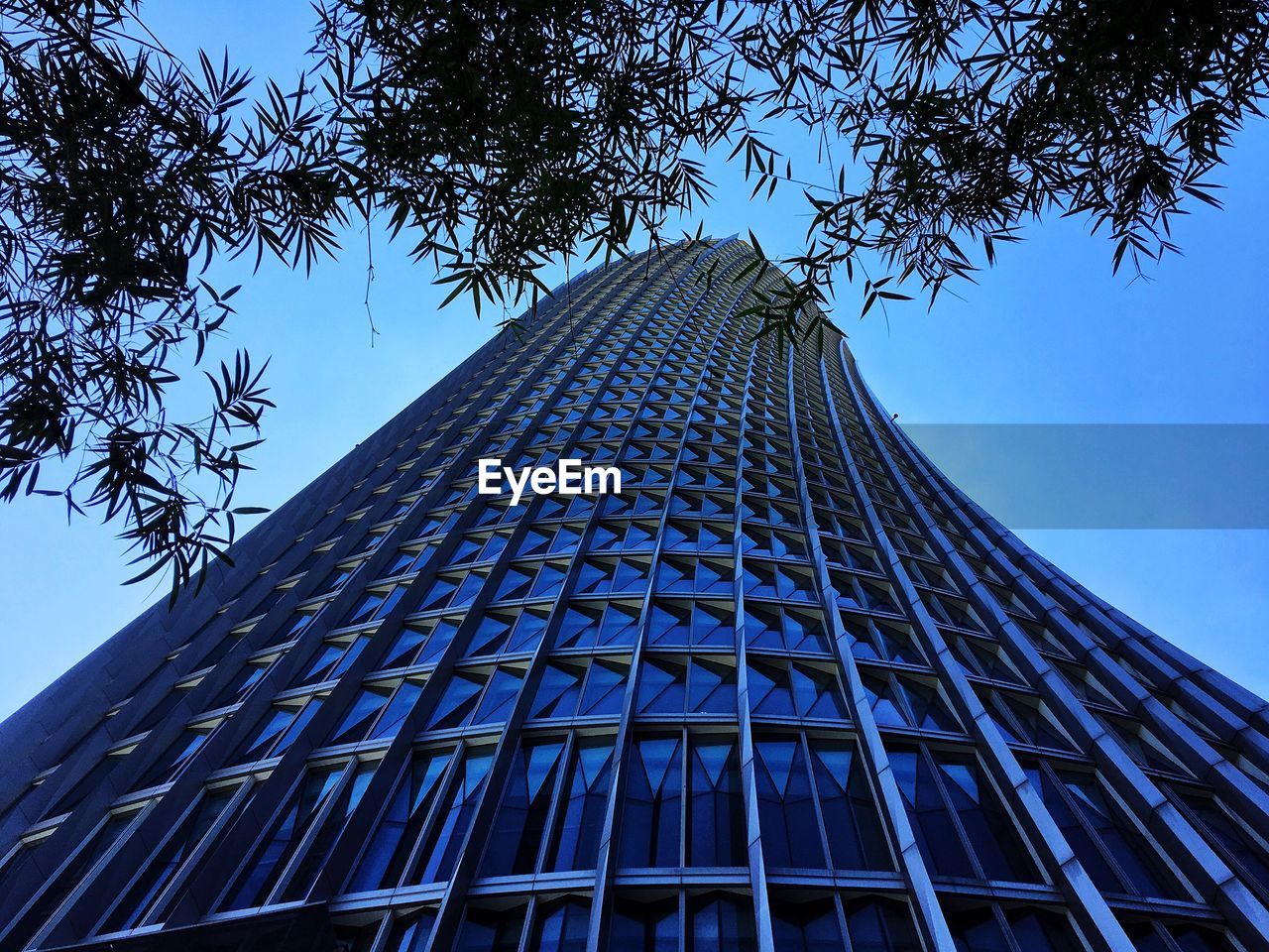 Low angle view of skyscraper against clear blue sky