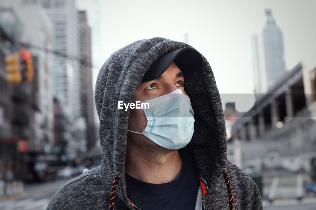 Man wearing mask and standing in city