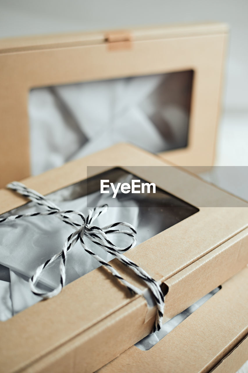 box, indoors, cardboard, cardboard box, gift, container, paper, no people, gift box, close-up, package, celebration, packing, focus on foreground, picture frame, technology, open, selective focus, ribbon