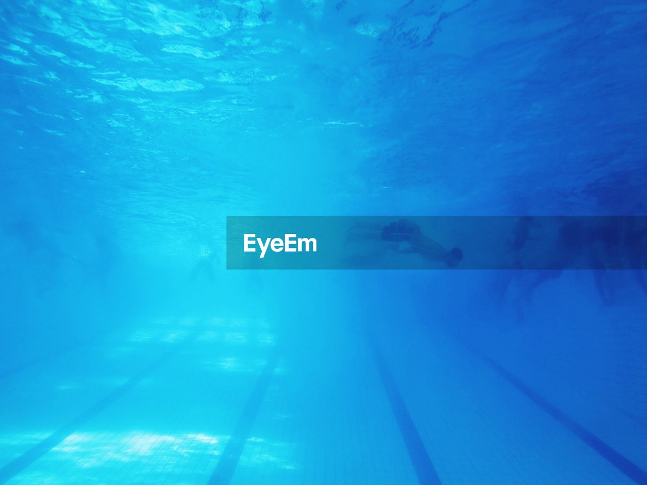 LOW ANGLE VIEW OF MEN SWIMMING IN POOL