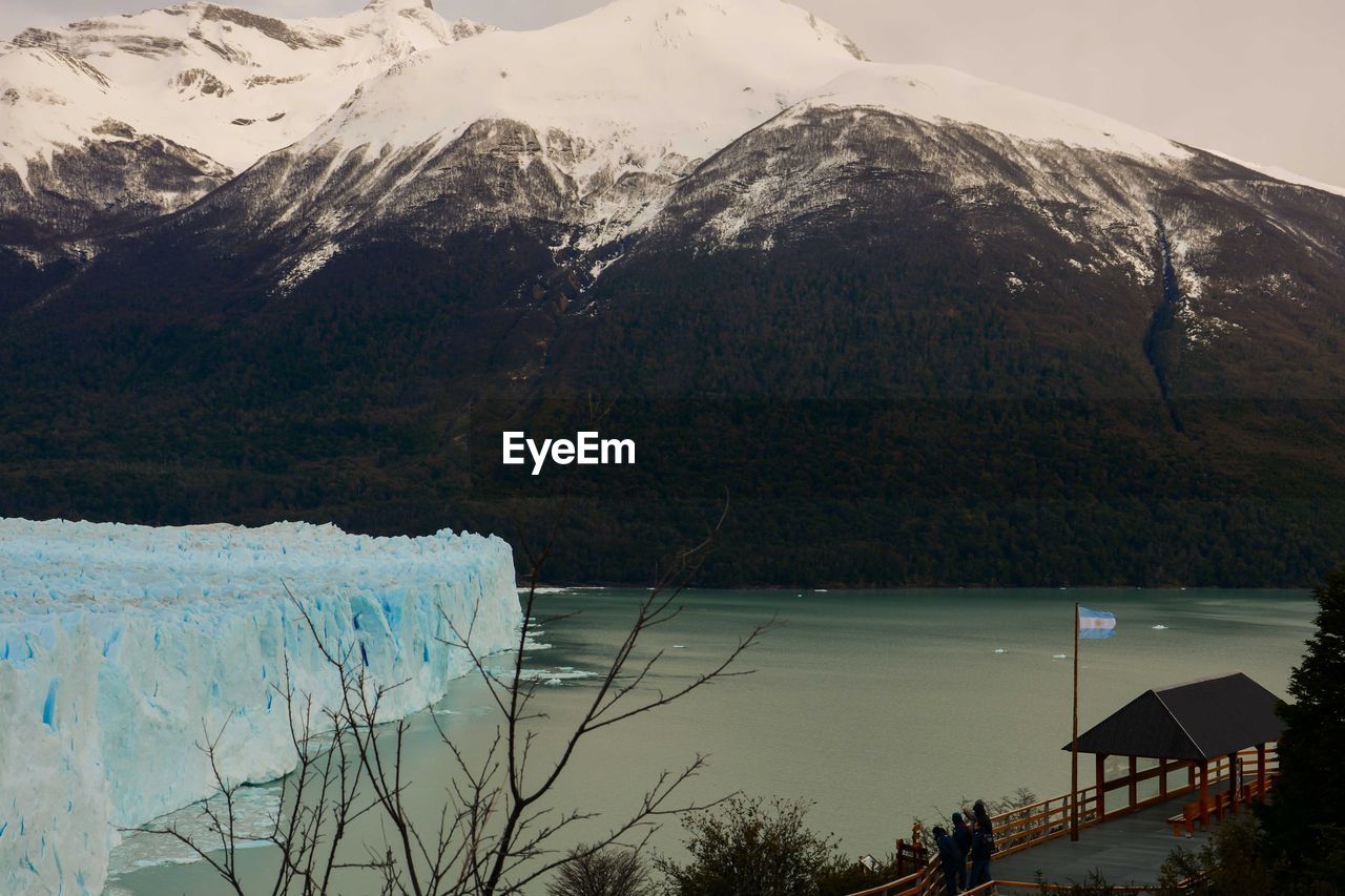 Perito moreno glacier by sea against snowcapped mountains