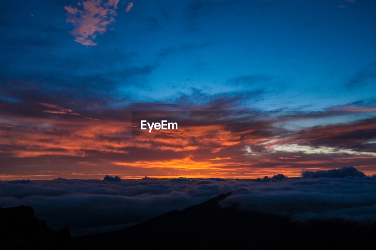 Scenic view of silhouette mountains against sky at sunset