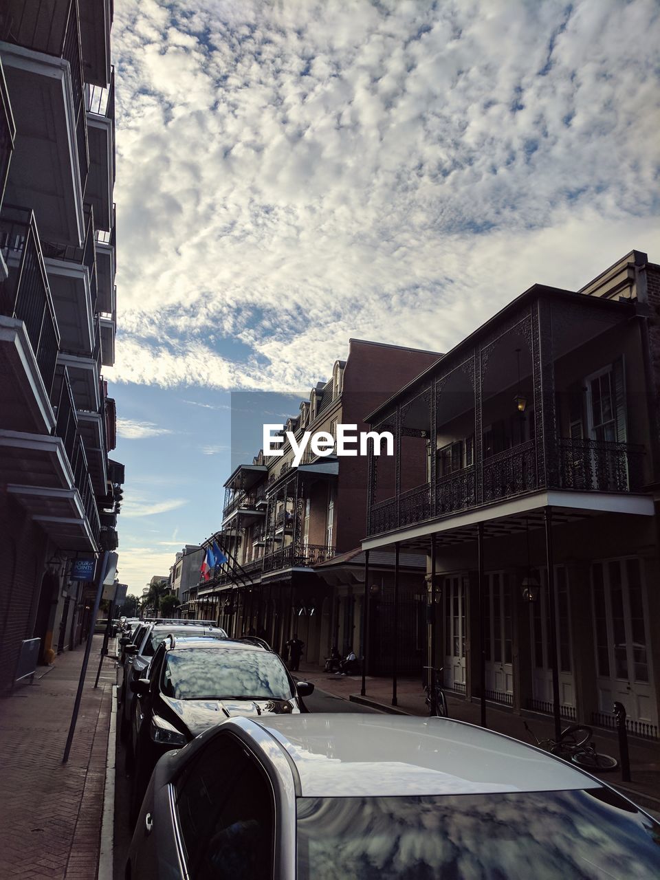 Vehicles on road against sky in city