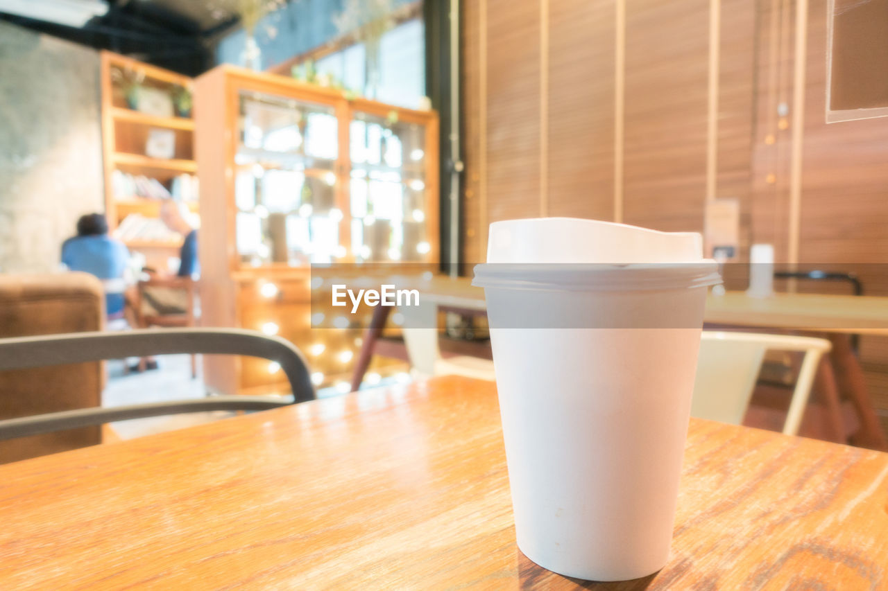 Close-up of disposable coffee cup on table at restaurant