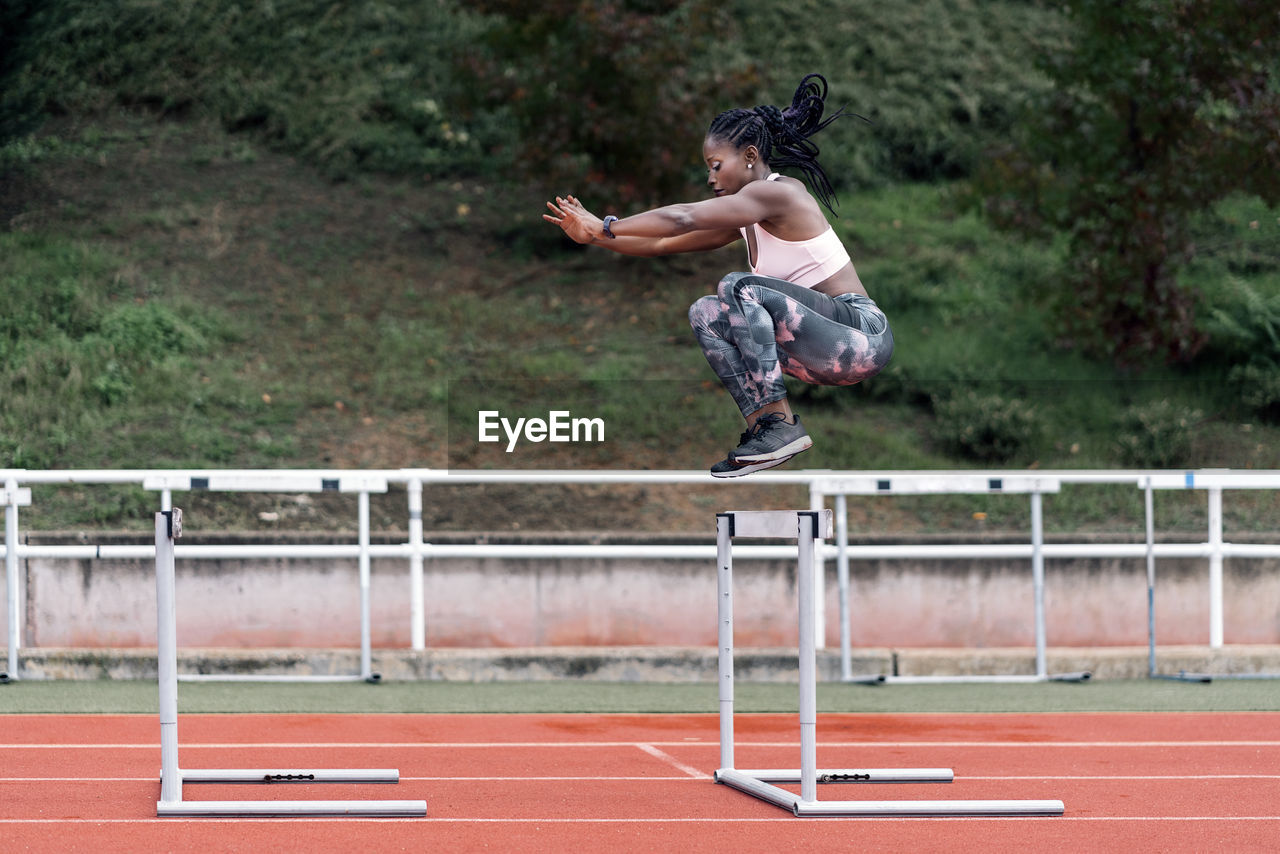 FULL LENGTH OF MAN JUMPING ON SKATEBOARD PARK