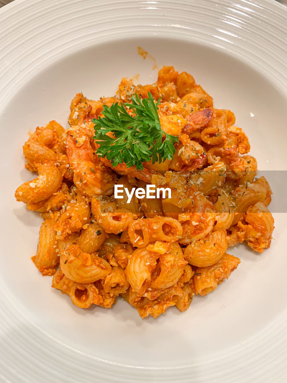 Stir fried macaroni with tomato sauce put on a plate ready to serve.