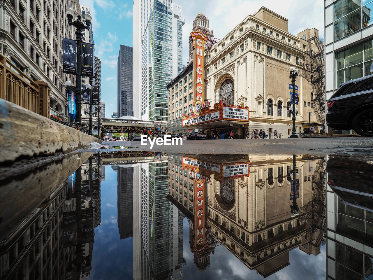 Reflection of buildings on puddle at street