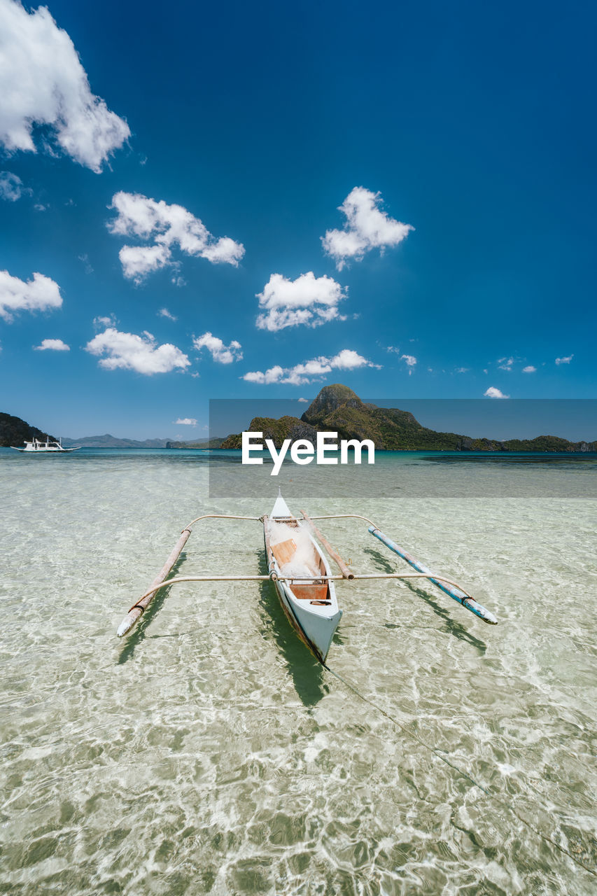 BOAT ON BEACH AGAINST SKY