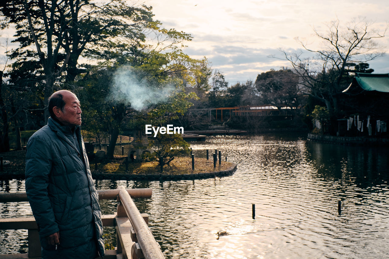 MAN STANDING IN LAKE AGAINST SKY