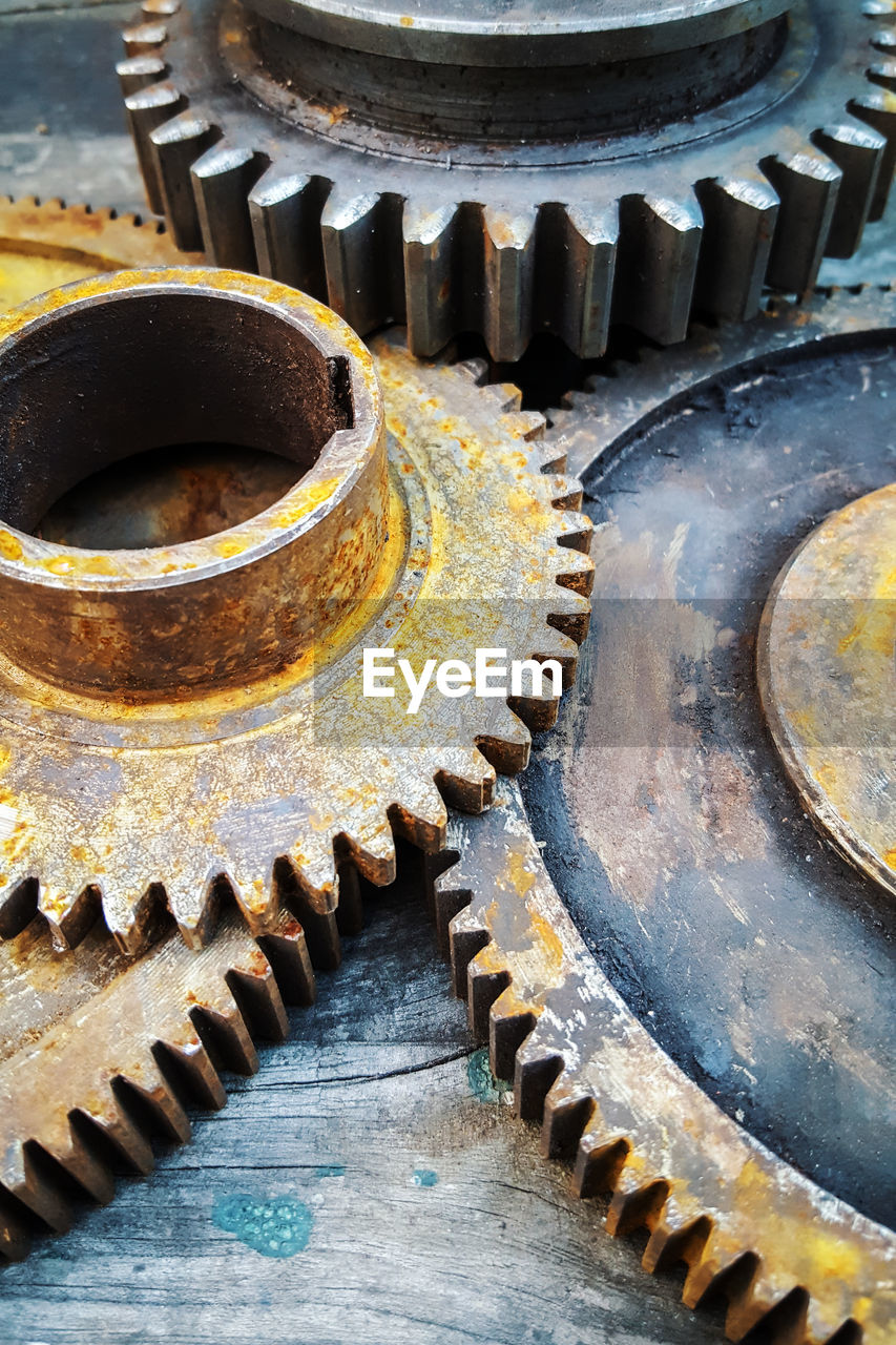 High angle view of rusty metallic gears on table