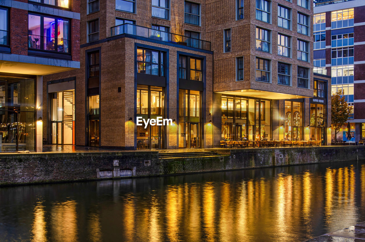 New housing development with quayside hospitality on the ground floor reflecting in canal