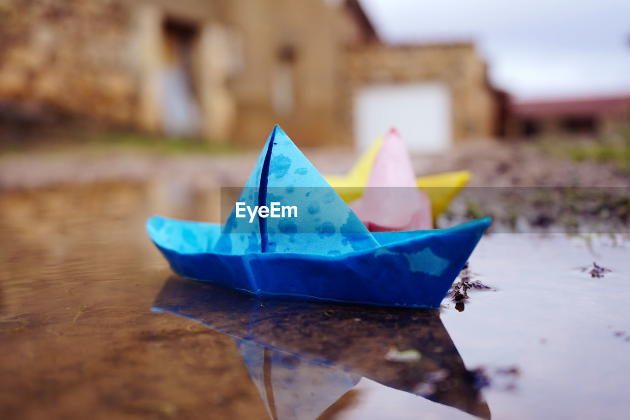 Close-up of multi colored paper boats floating on water