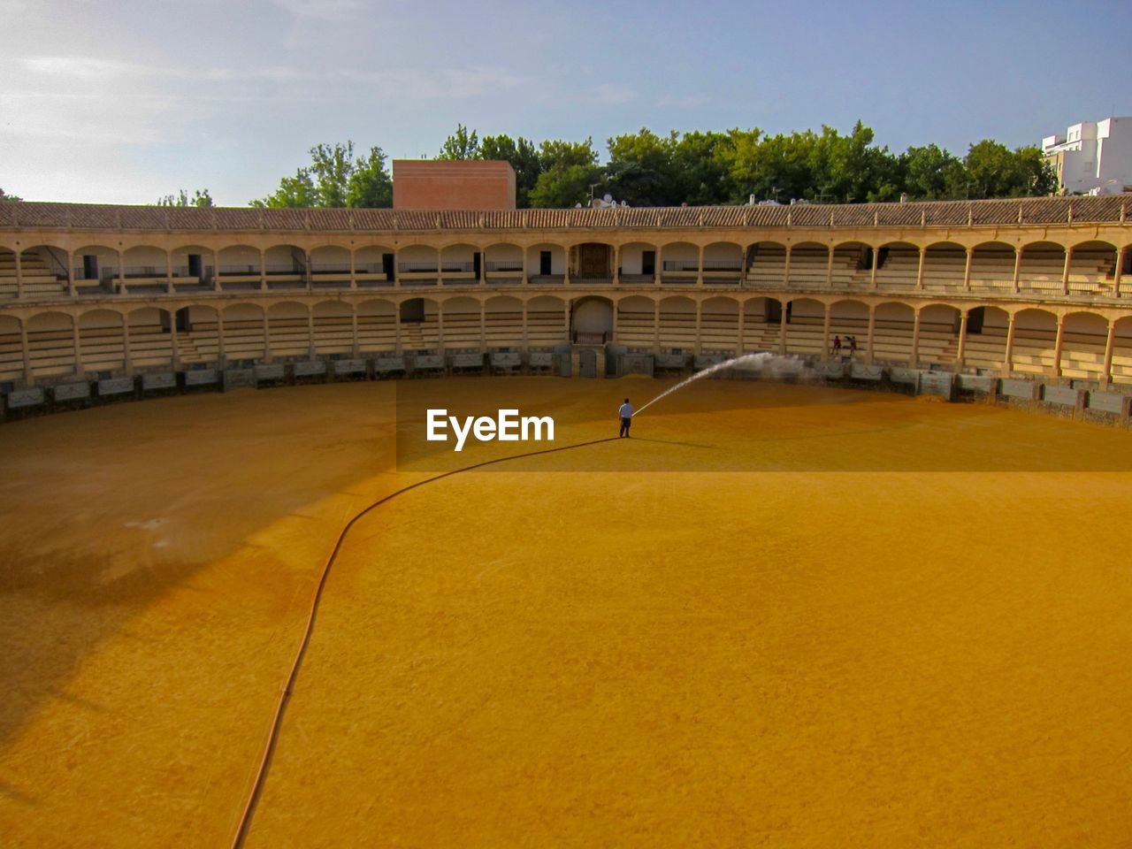 Man sprinkling water at bullfight stadium