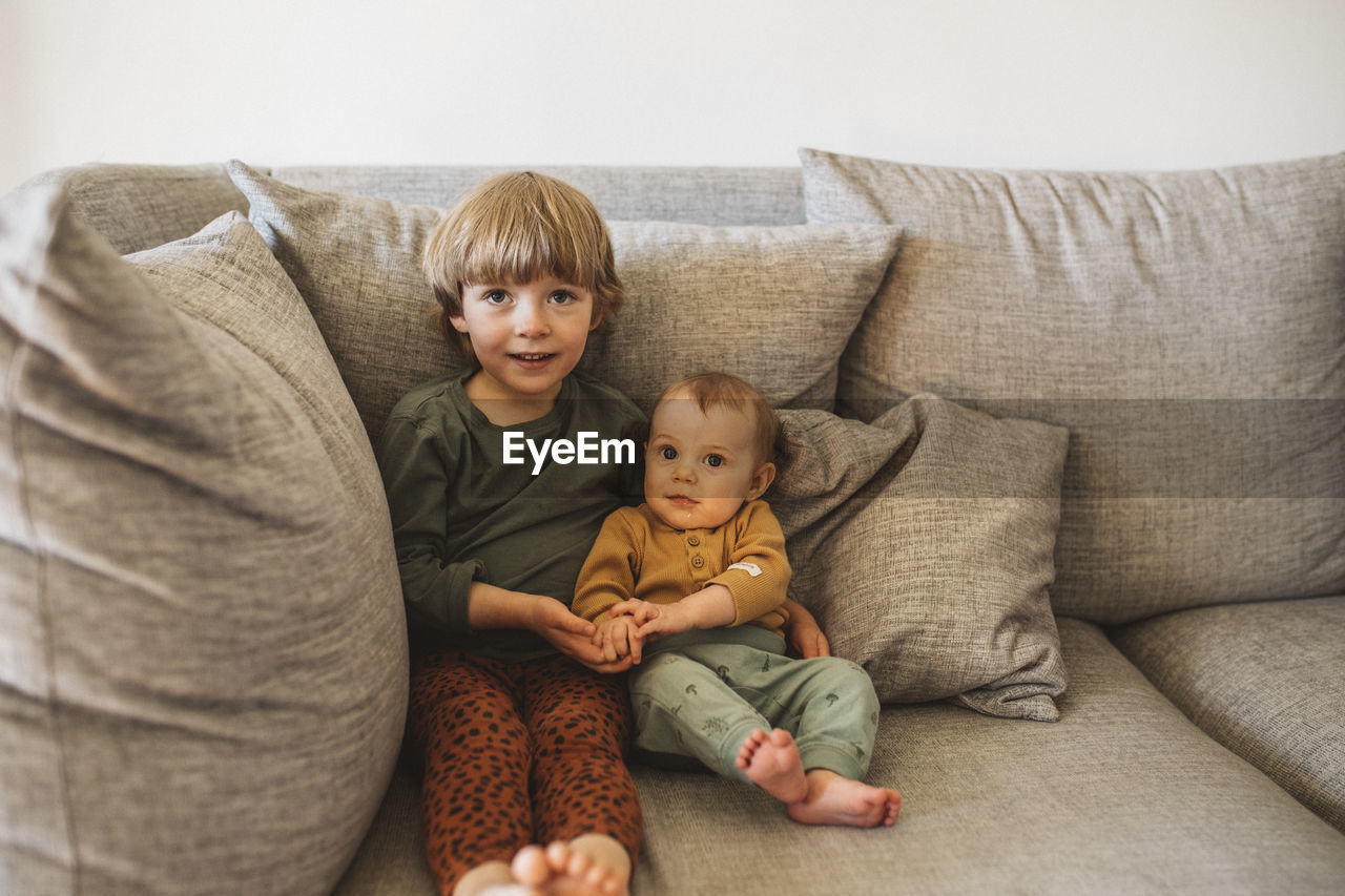 Sibling sitting on sofa