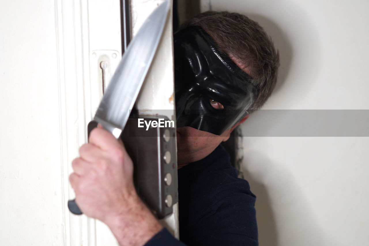 CLOSE-UP OF MAN HOLDING CAMERA IN MIRROR