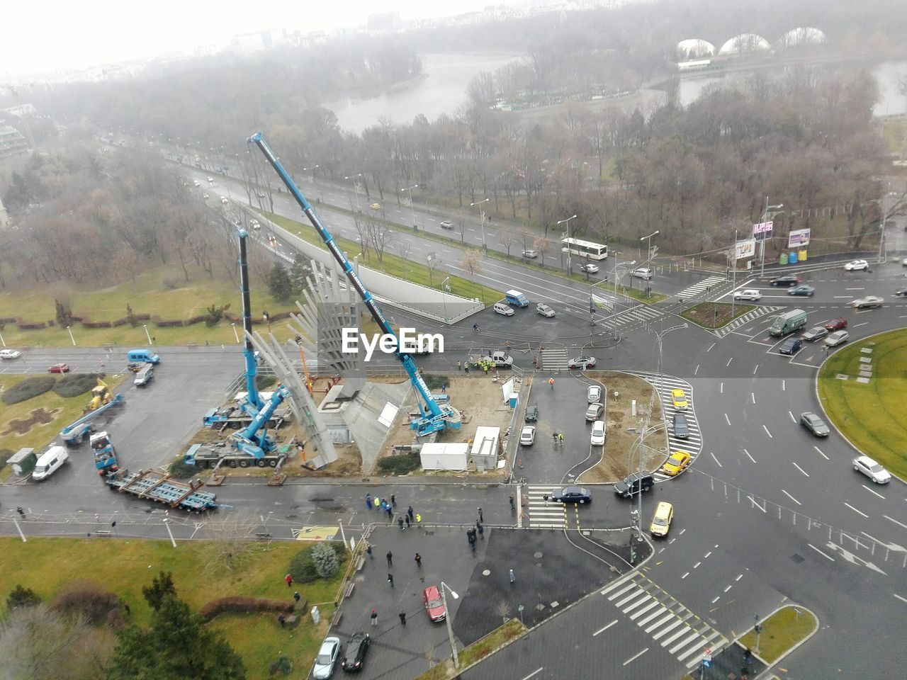 High angle view of construction vehicles at piata presei libere seen from city gate towers in rain