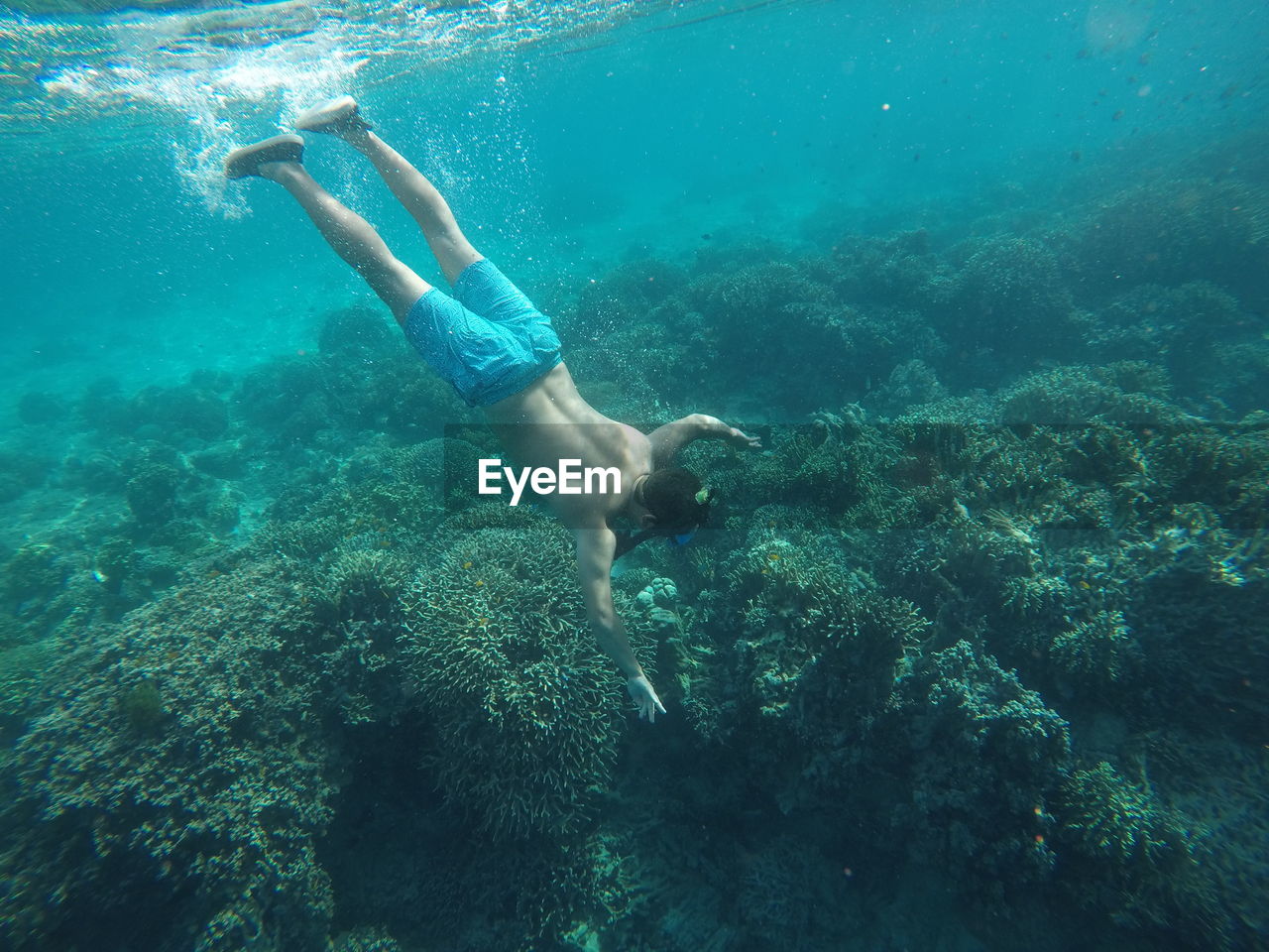 Full length of shirtless man swimming in sea