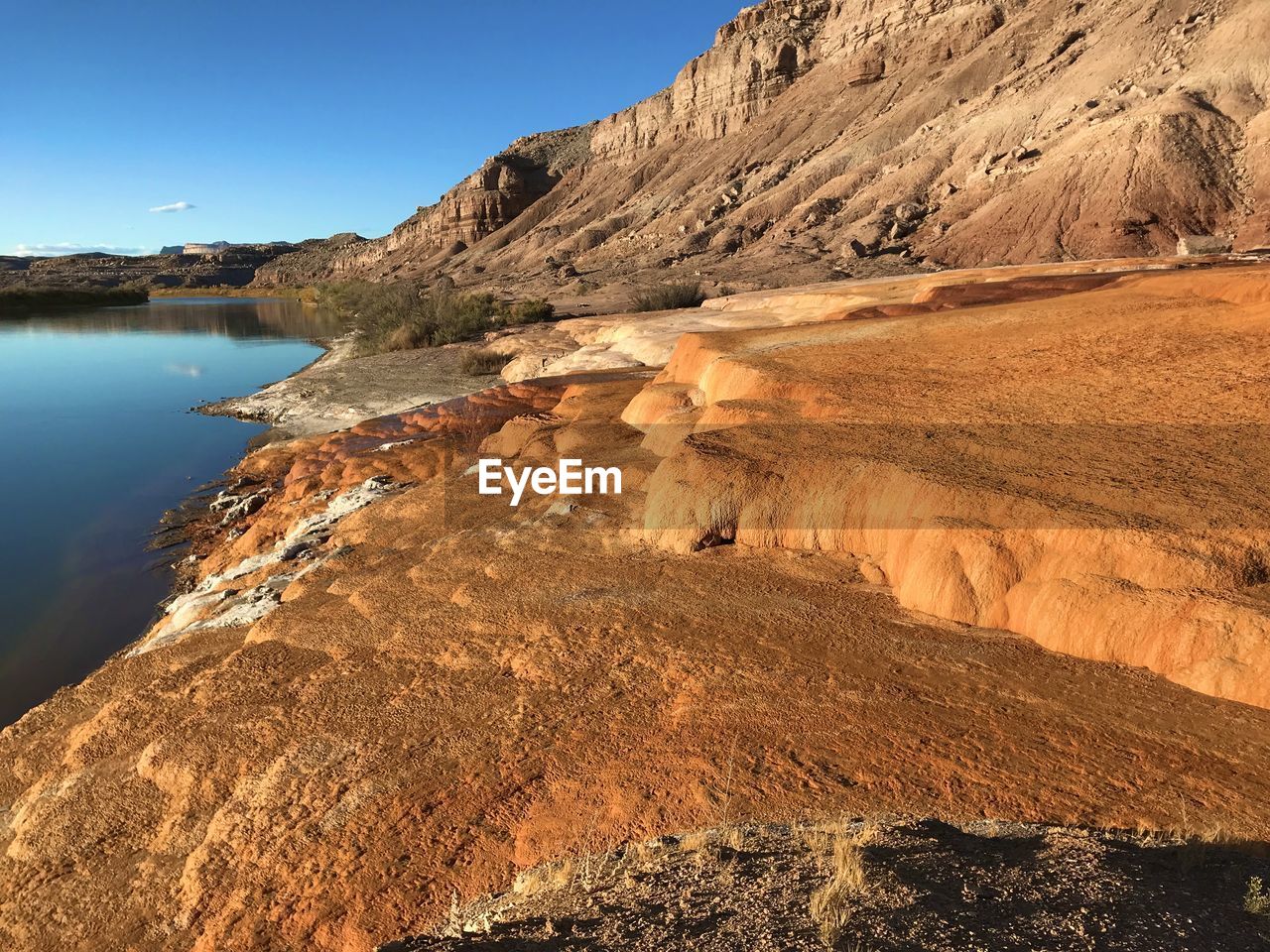 Scenic view of rocks on shore against sky