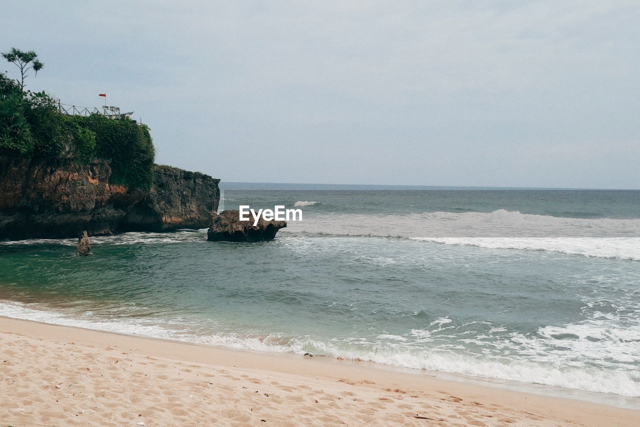 sea, water, land, beach, sky, body of water, scenics - nature, beauty in nature, nature, sand, shore, vacation, tranquility, horizon over water, wave, ocean, tranquil scene, horizon, motion, travel destinations, idyllic, wind wave, coastline, coast, day, holiday, rock, travel, trip, no people, outdoors, tourism, water sports, sports, water's edge, cliff, tree, non-urban scene, cloud, environment, bay, seascape, plant, island