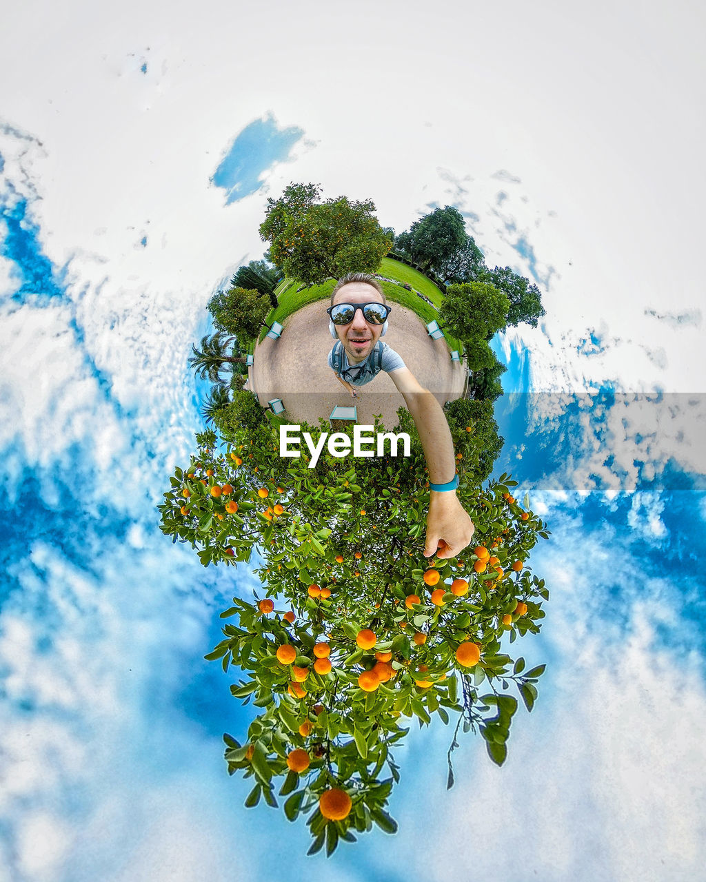 MAN STANDING BY PLANT AGAINST SKY