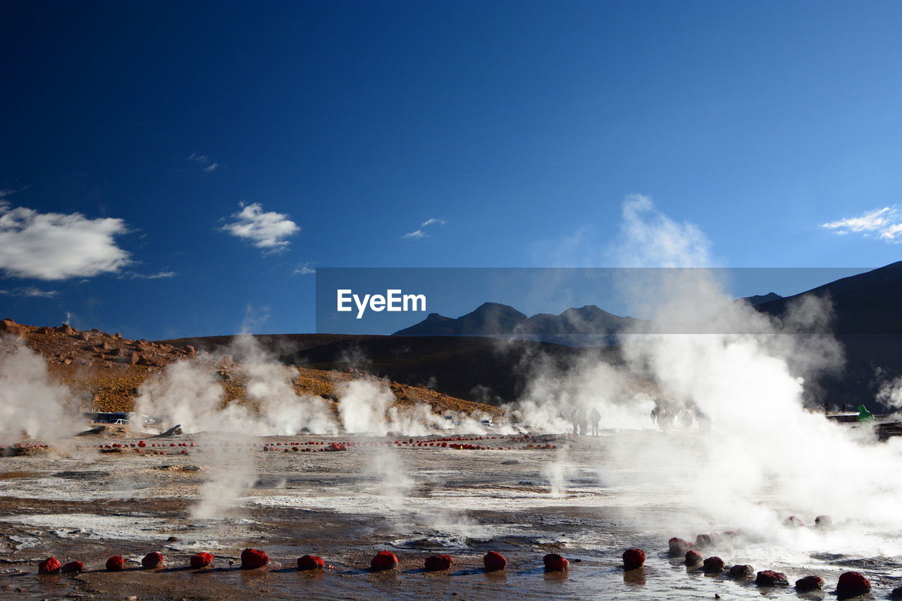 Scenic view of smoke emitting from landscape against sky