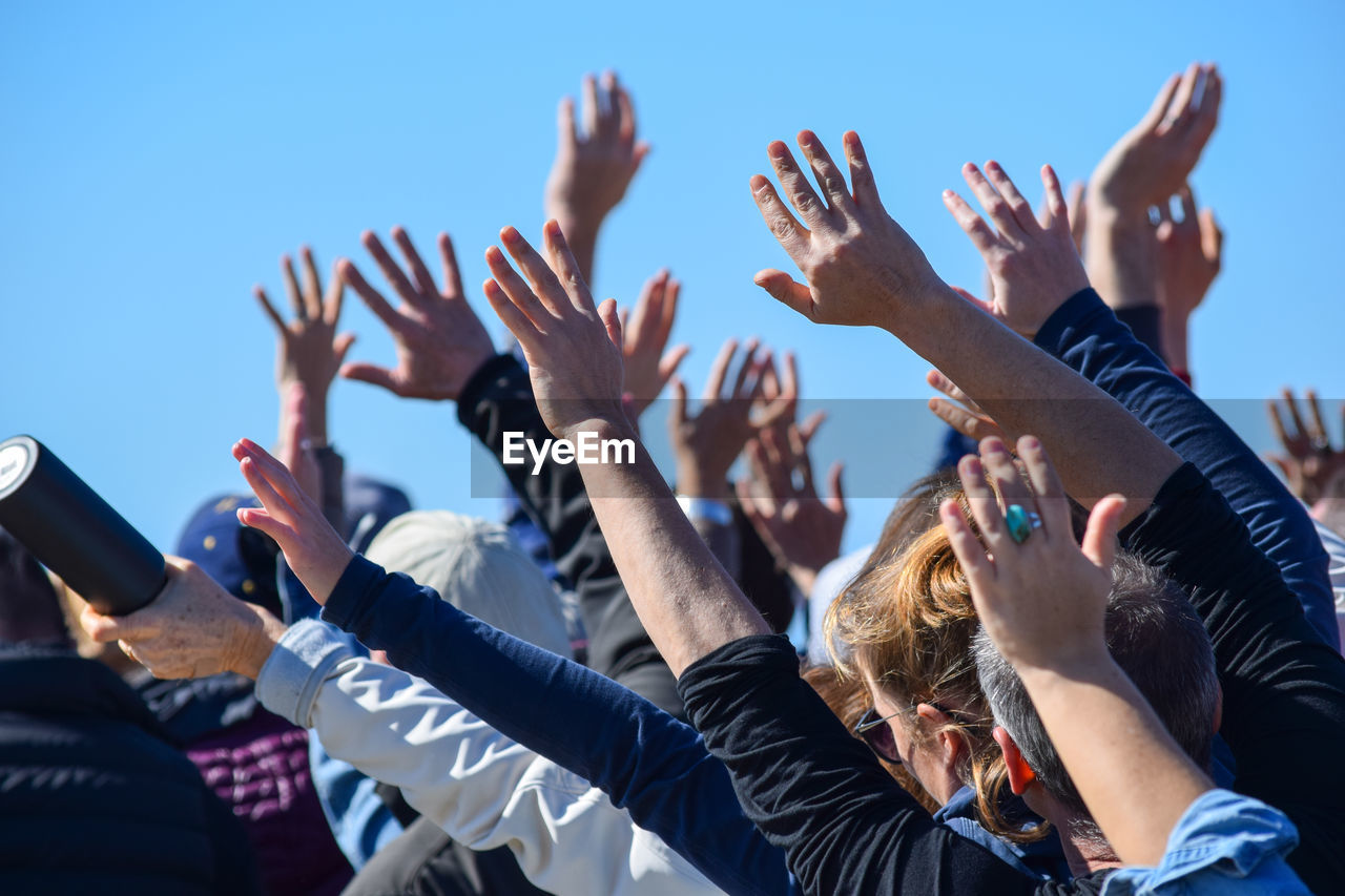 Protestors with hands raised at a protest music festival 