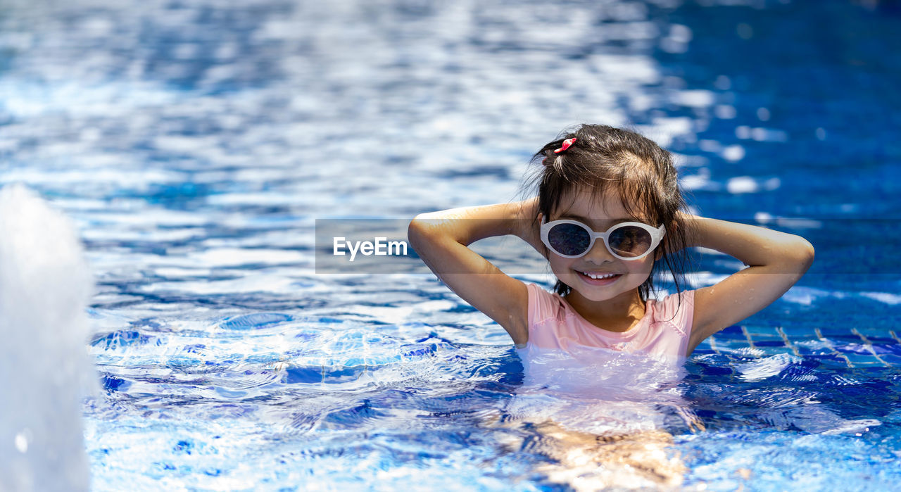 PORTRAIT OF GIRL SWIMMING IN WATER